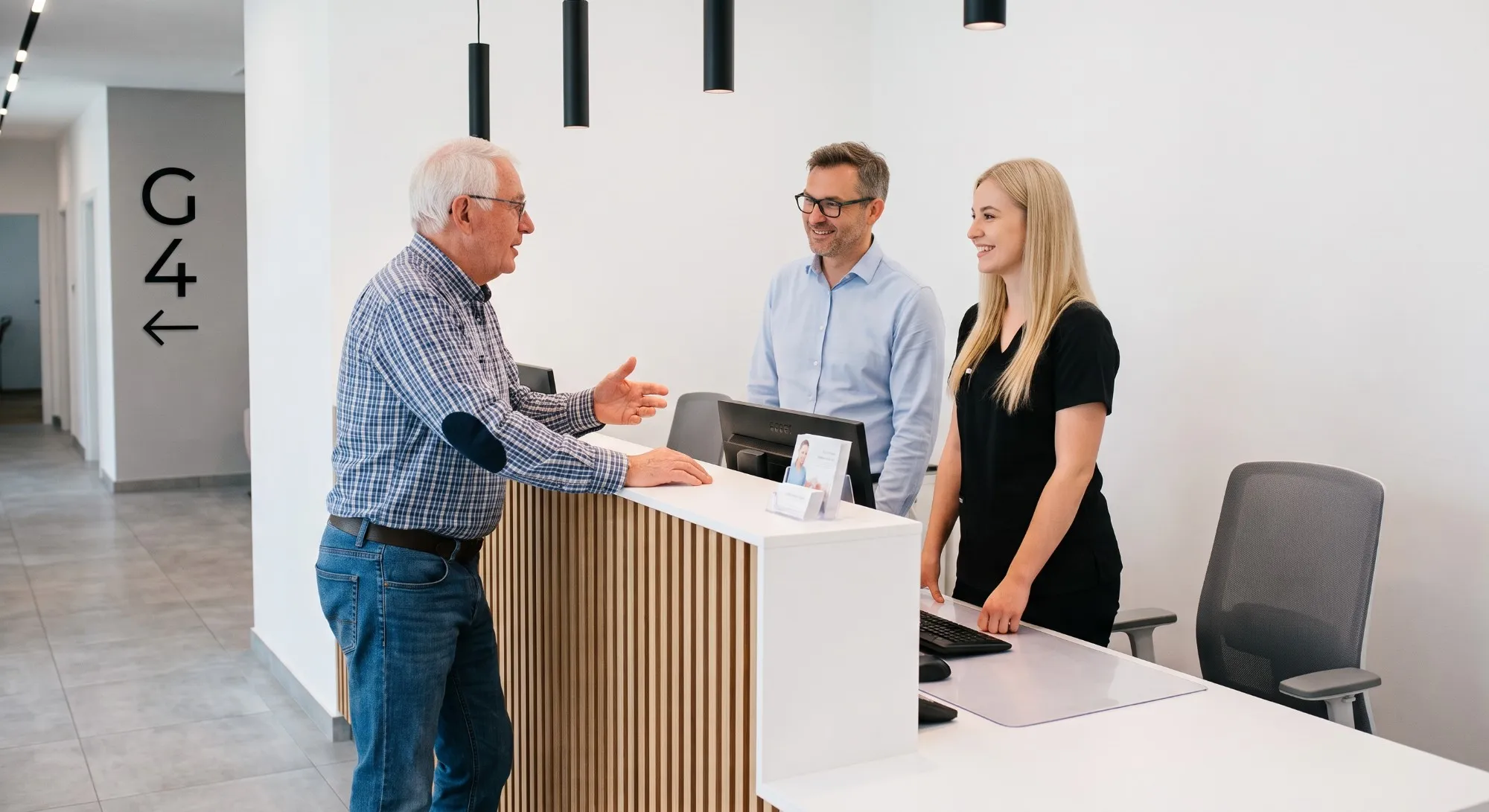 Älterer Patient im Gespräch mit dem Praxisteam am Empfang einer Zahnklinik